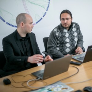 Two people looking at screen and discussing